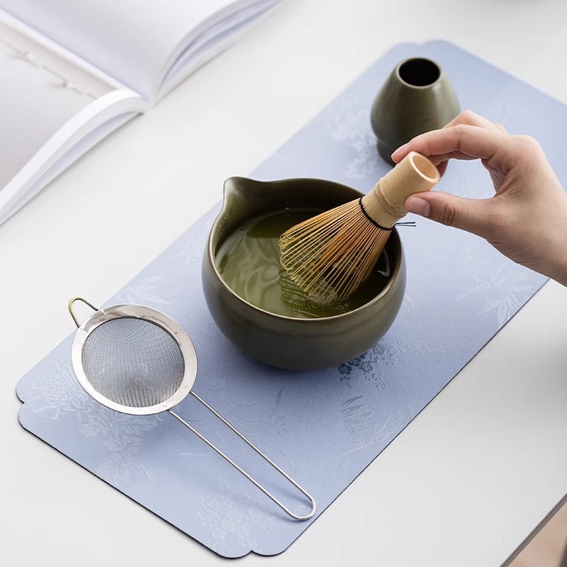 Whisking matcha to a foam in the Kumora dark green ceramic bowl