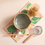 Kumora 7-piece matcha set in Amber — flat top-down view of the whole set, sage-lined amber bowl with spout at right