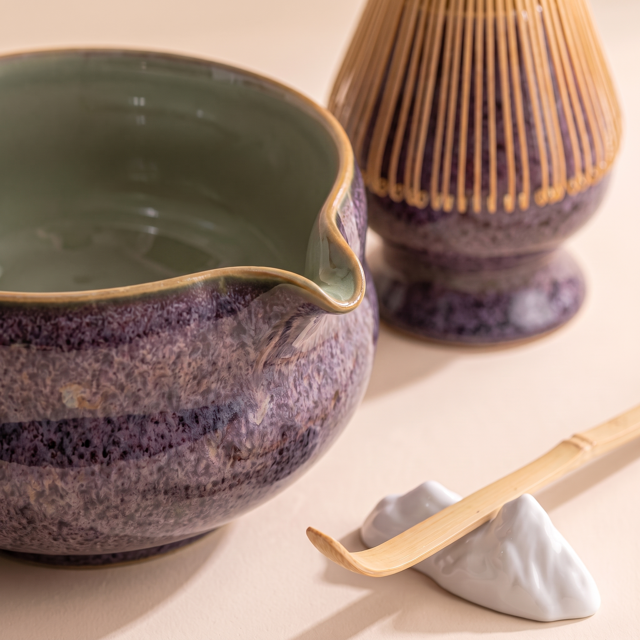 Kumora 7-piece matcha set in Aubergine — macro close-up of the beaked rim, tan rim line and whisk docked on its stand