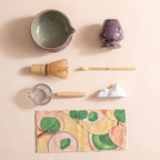 Kumora 7-piece matcha set in Aubergine — overhead flat-lay of all seven pieces, bowl, whisk, scoop, sifter, rest and mat